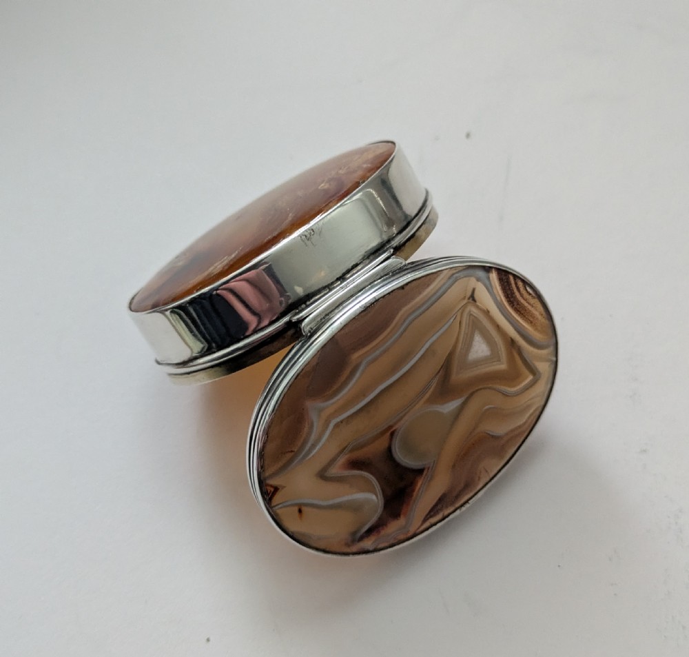 An oval Edwardian sterling silver box featuring polished natural agate stone panels on the hinged top and base. View III