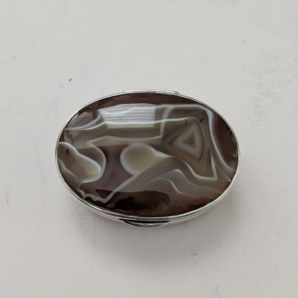 An oval Edwardian sterling silver box featuring polished natural agate stone panels on the hinged top and base. View IV