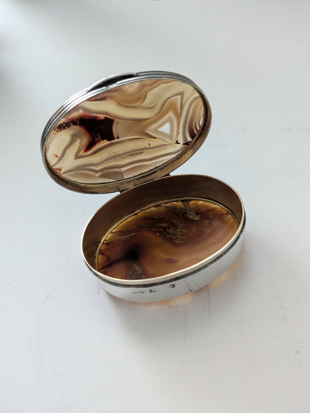 An oval Edwardian sterling silver box featuring polished natural agate stone panels on the hinged top and base. View V