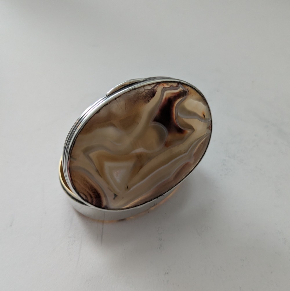 An oval Edwardian sterling silver box featuring polished natural agate stone panels on the hinged top and base. View VI