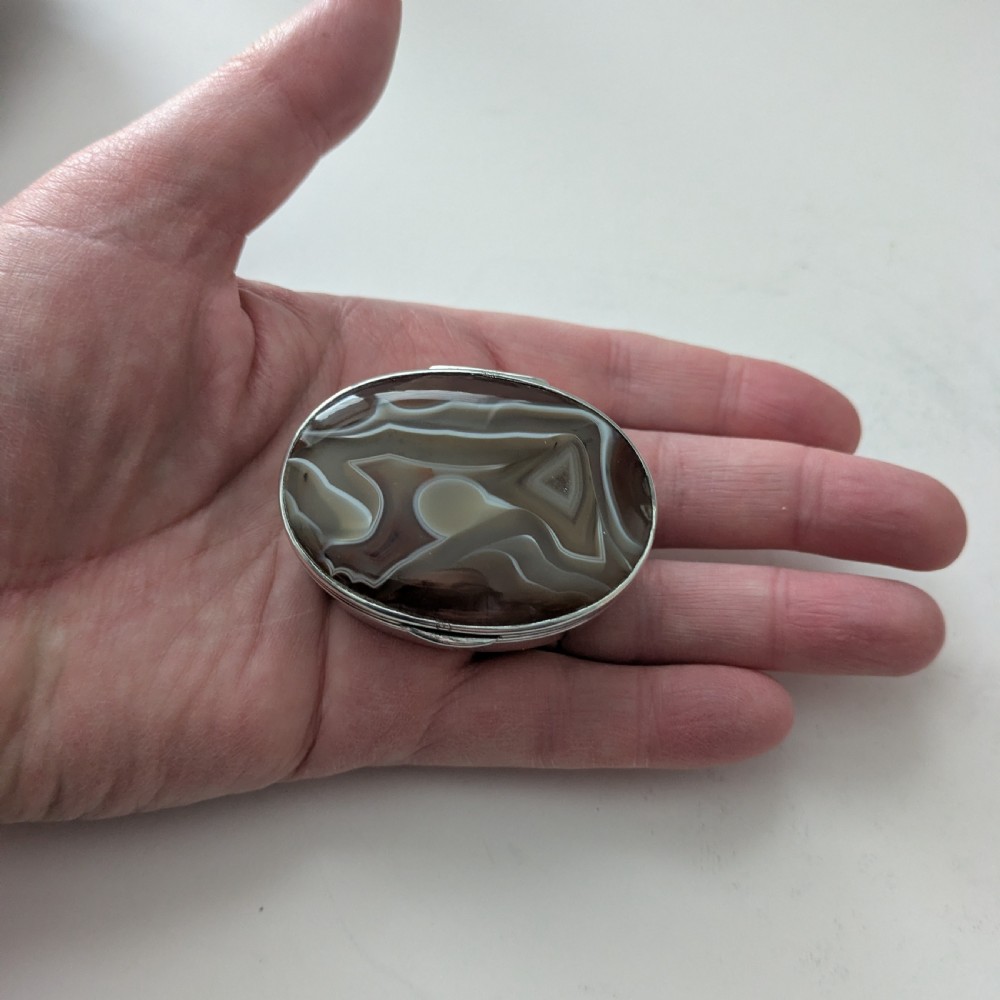 An oval Edwardian sterling silver box featuring polished natural agate stone panels on the hinged top and base. View VIII