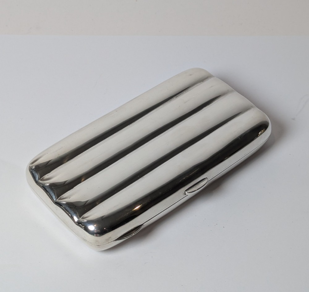 A polished sterling silver hinged cigar case featuring four rounded longitudinal compartments and smooth exterior edges. View II