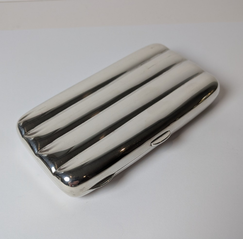 A polished sterling silver hinged cigar case featuring four rounded longitudinal compartments and smooth exterior edges. View IV