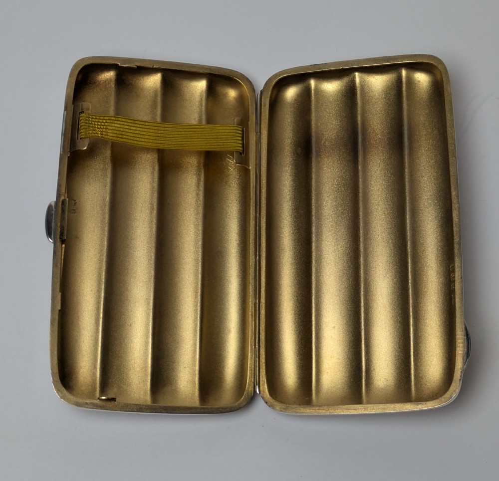 A polished sterling silver hinged cigar case featuring four rounded longitudinal compartments and smooth exterior edges. View IX