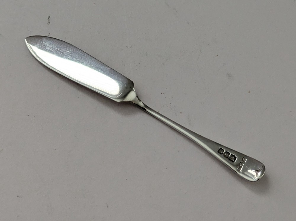 A boxed set of six circular sterling silver butter dishes paired with six matching butter knives inside a silk-lined presentation case. View XII