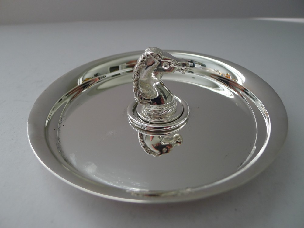 A circular polished silver dish featuring a sculpted equestrian horse head handle at the centre. View VIII