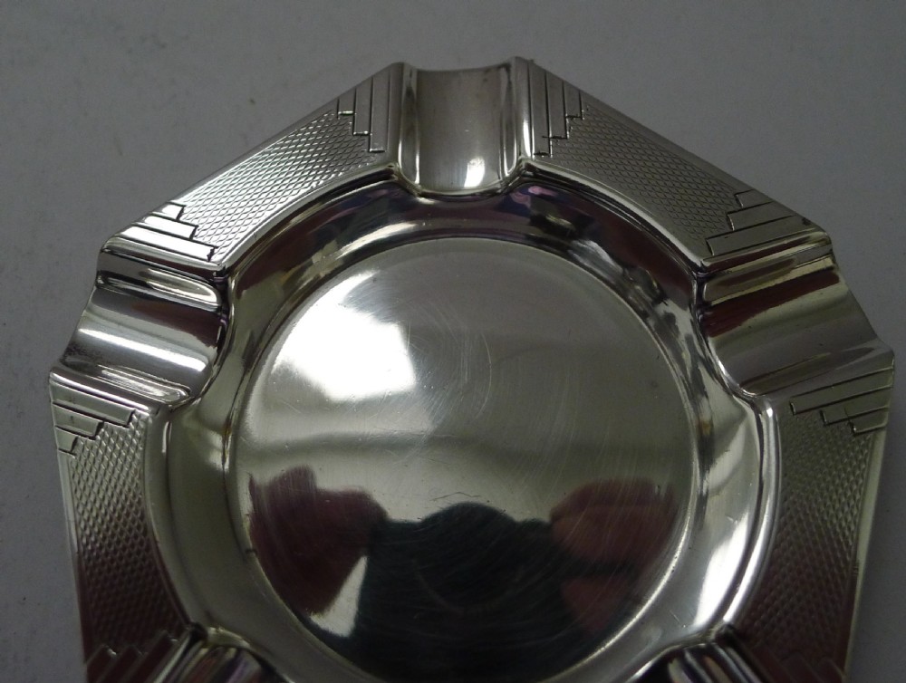 A pentagonal sterling silver Art Deco ashtray featuring geometric stepped corners, engine-turned engraving, and five integrated cigarette rests. View V