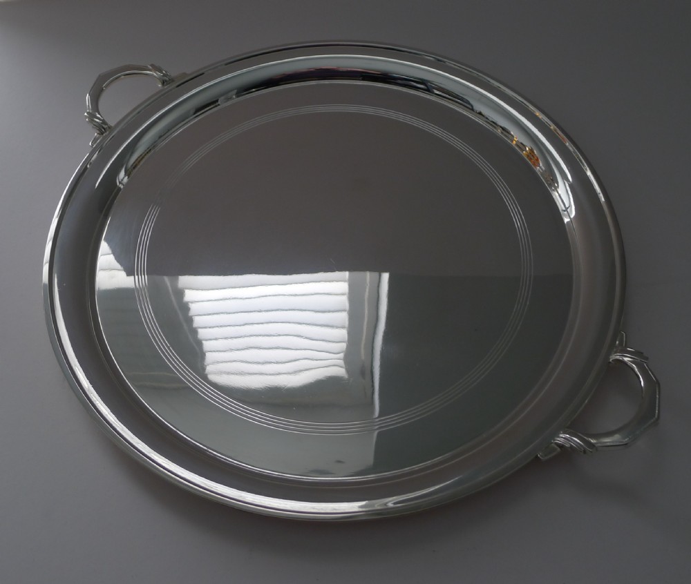 A circular silver-plated Art Deco cocktail tray featuring concentric line engraving on the flat surface and two stylized side handles. View IV