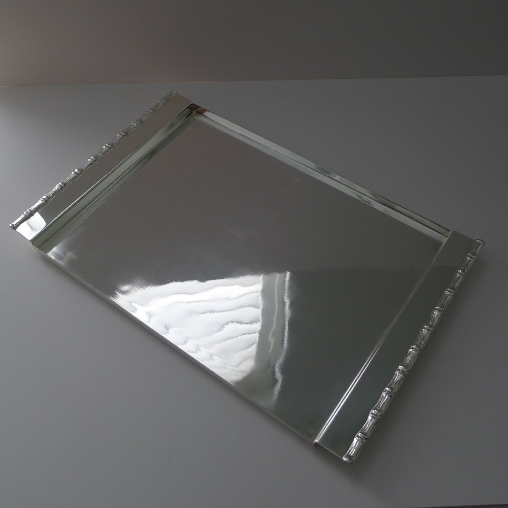 A rectangular polished silver-plated tray featuring cast bamboo-style handles along two opposite ends.