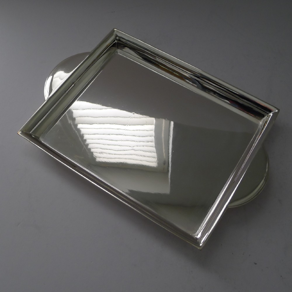 A polished rectangular silver-plated cocktail tray featuring a stepped moulded rim and integrated curved handles.