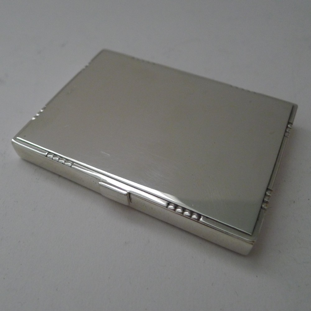 A low-profile rectangular sterling silver box with a hinged lid, polished reflective finish, and subtle beaded accents along the rim.