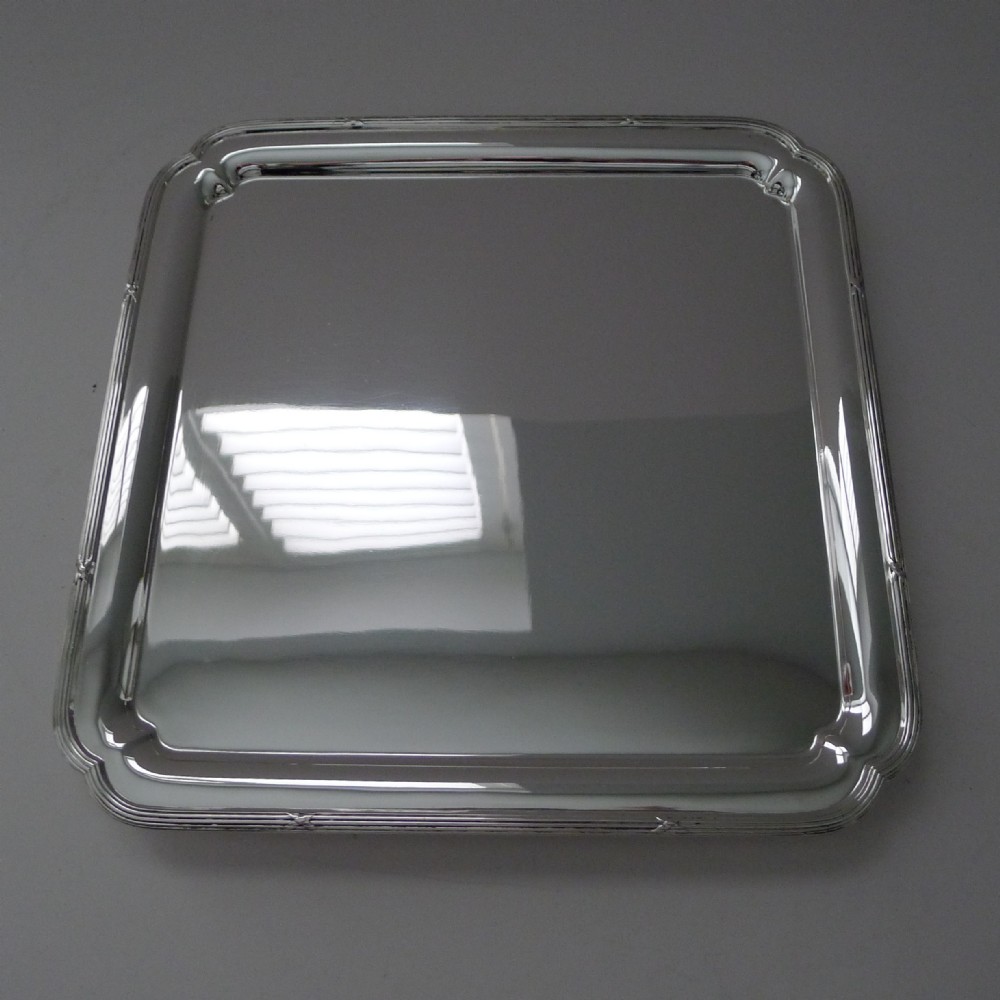 A square silver-plated drinks tray with rounded corners, a polished reflective surface, and a subtle reeded border.