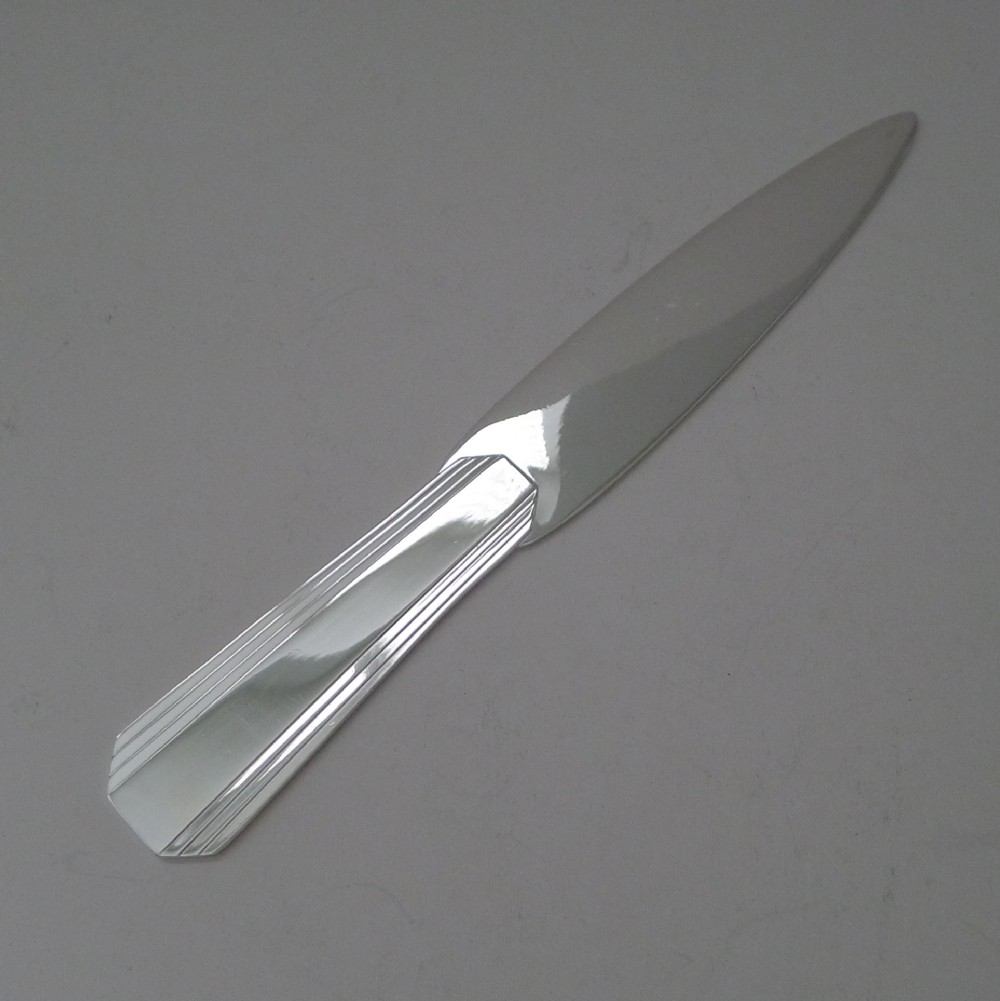 A silver-plated Art Deco paper knife with a fluted geometric handle and smooth tapered blade.
