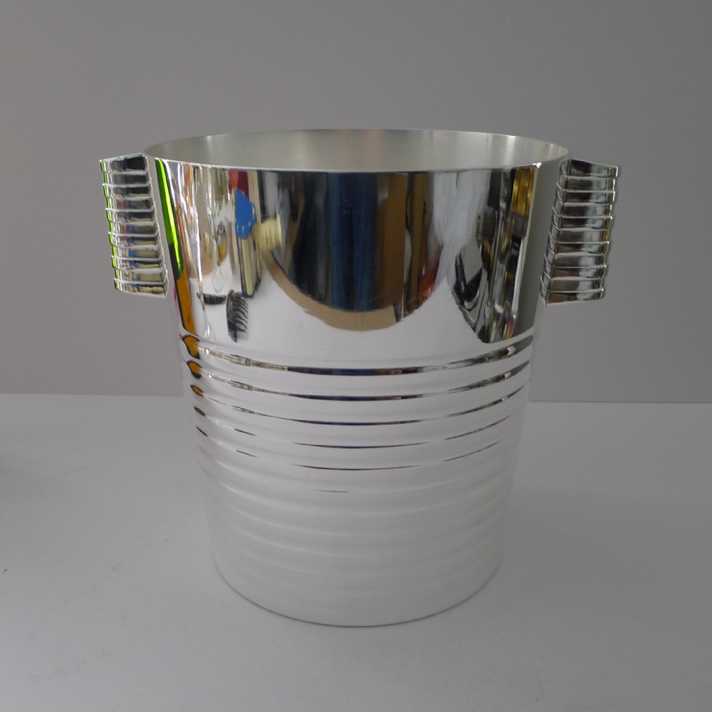 An Art Deco silver-plated champagne cooler featuring horizontal ridged bands and tiered side handles.