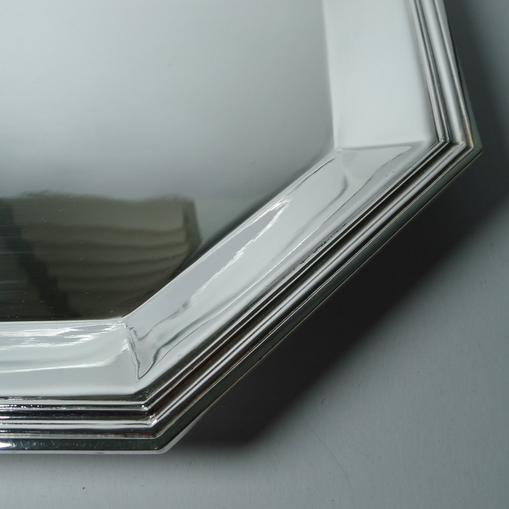 An octagonal silver-plated Art Deco tray featuring a polished reflective surface and a stepped moulded border. View II