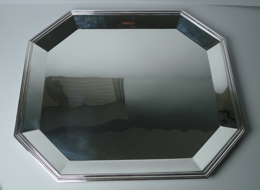 An octagonal silver-plated Art Deco tray featuring a polished reflective surface and a stepped moulded border. View V