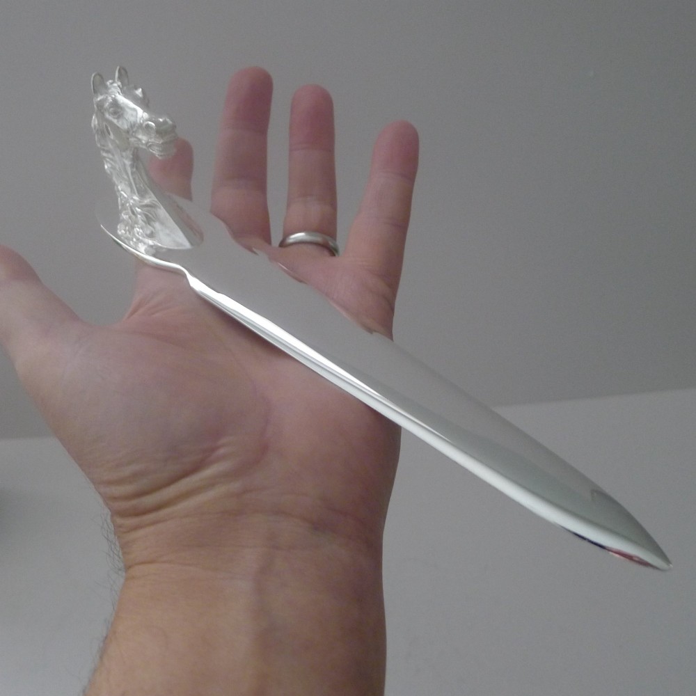 A silvered bronze letter opener featuring a detailed sculpted horse head handle and a polished, tapered blade resting on a neutral background. View X