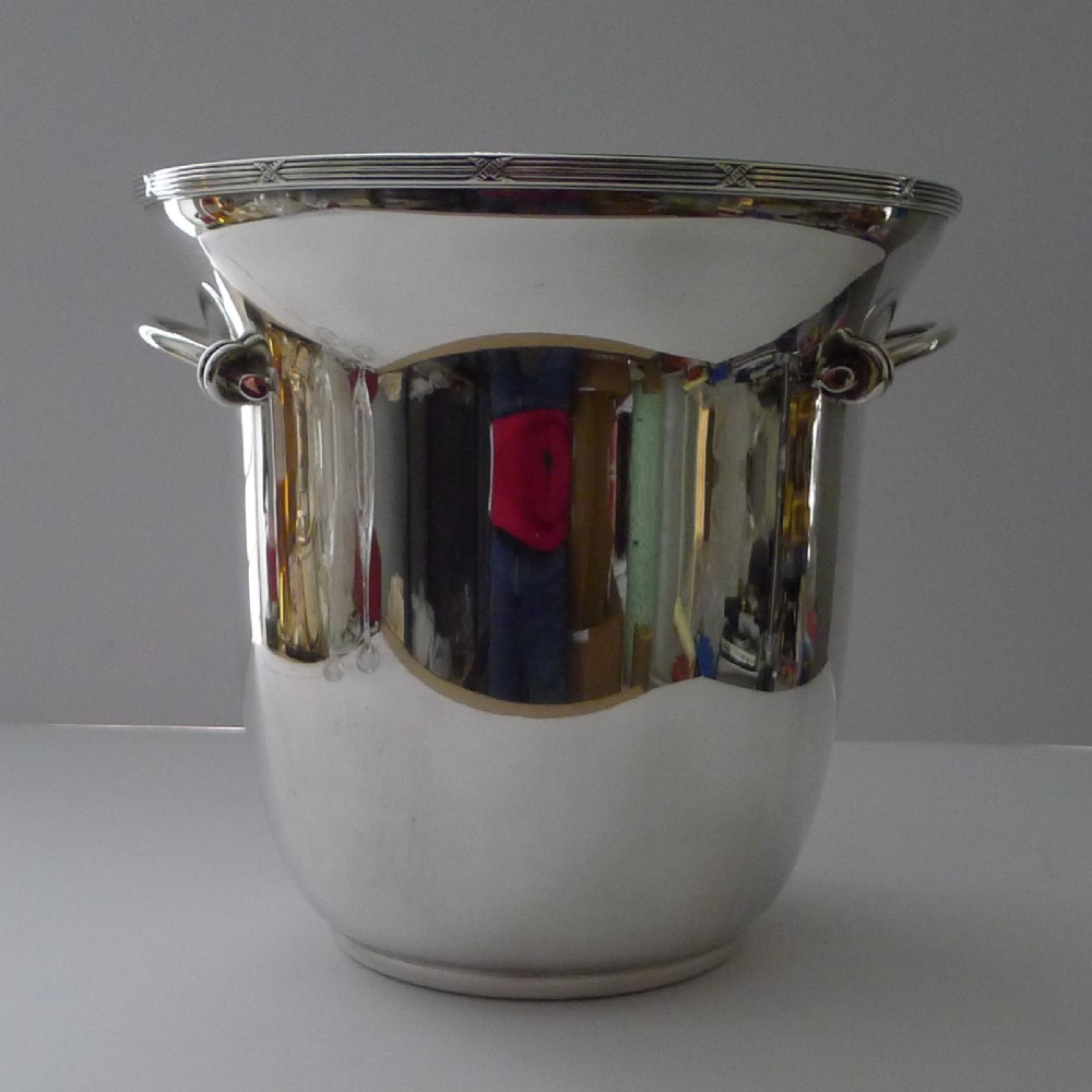A polished silver-plated French champagne bucket with twin side handles and a detailed reeded rim.