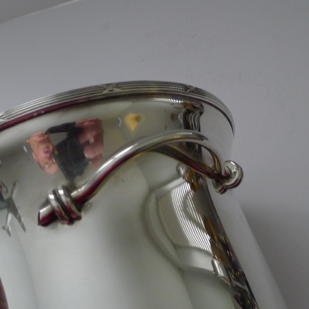 A polished silver-plated French champagne bucket with twin side handles and a detailed reeded rim. View X
