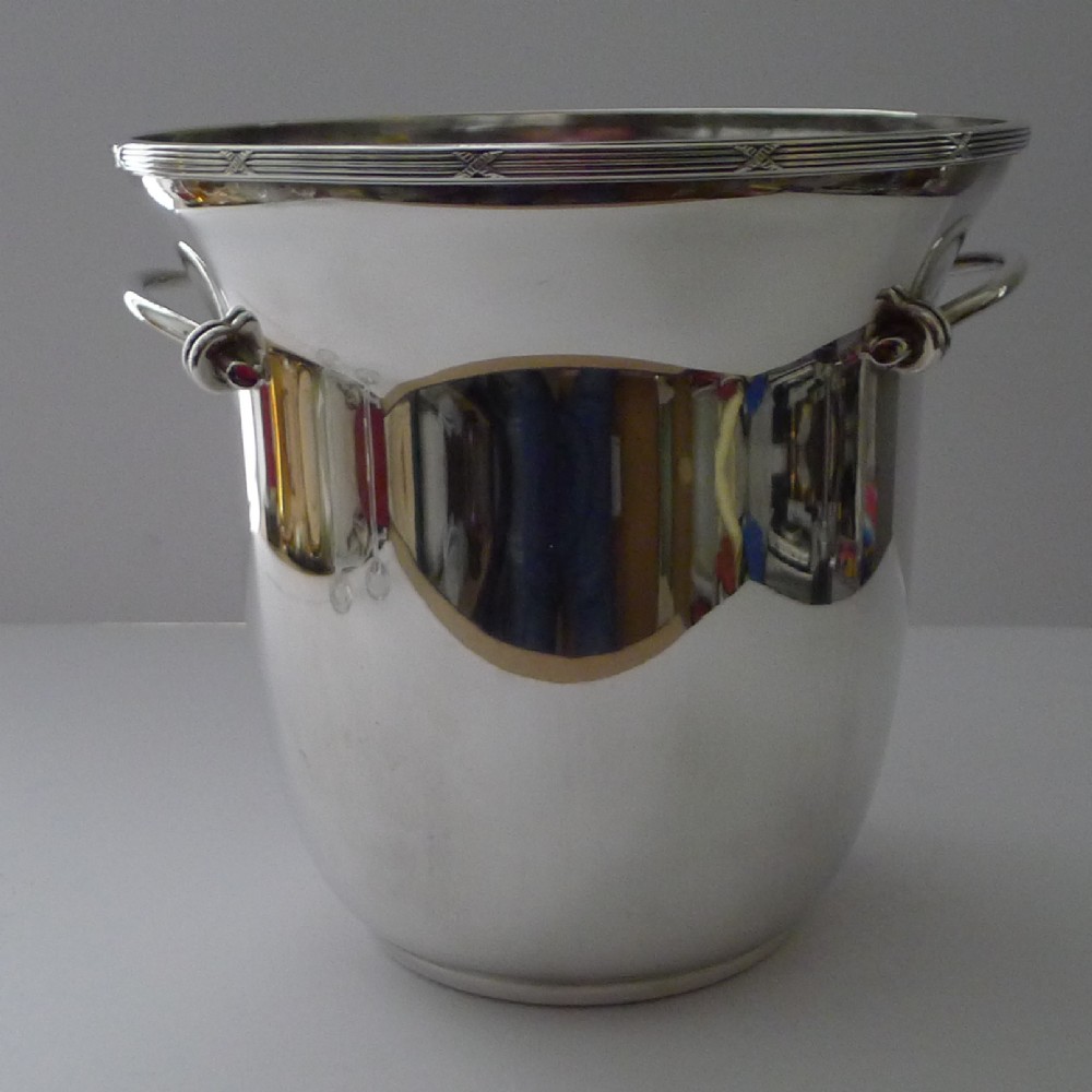 A polished silver-plated French champagne bucket with twin side handles and a detailed reeded rim. View XII