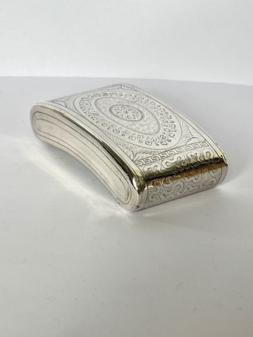 fig 1. A curved antique sterling silver pocket snuff box featuring elaborate hand engraving and a flush hinge.