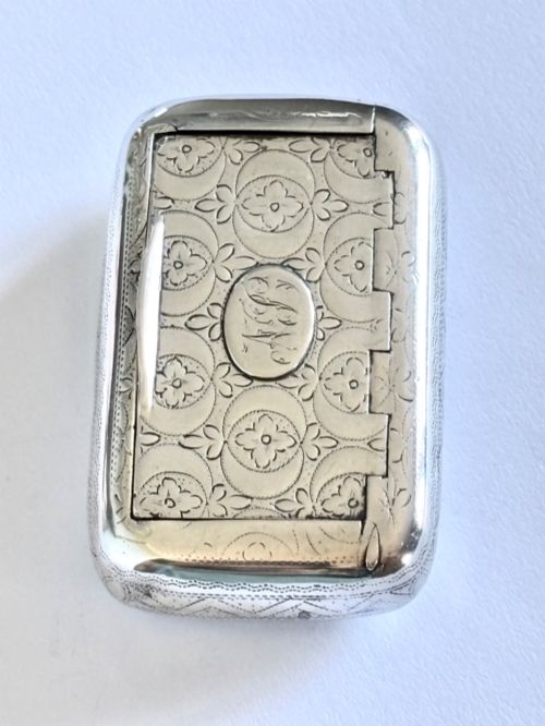 fig 1. A small rectangular George III sterling silver snuff box with bright-cut floral engraving and a central oval cartouche.