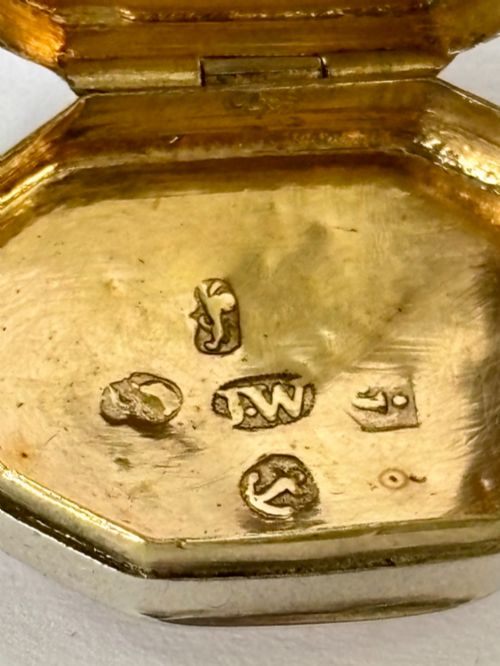 fig 1. An open George III octagonal sterling silver vinaigrette displaying a gilded interior with a perforated cover and makers stamp.