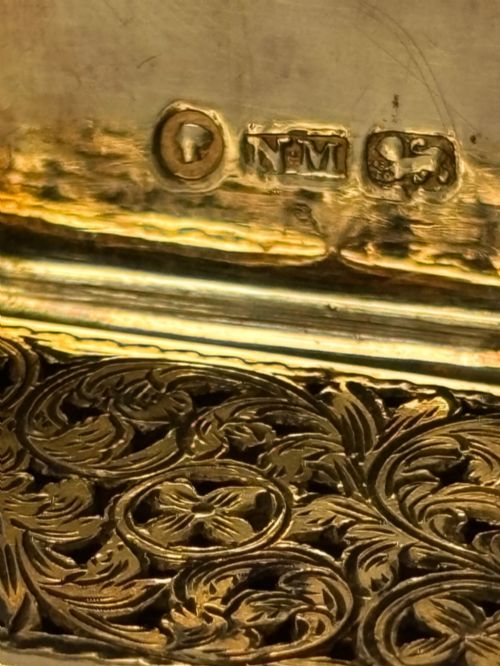fig 1. An open Early Victorian silver gilt vinaigrette showing a floral pierced interior grille and hallmarks on the inside lid.