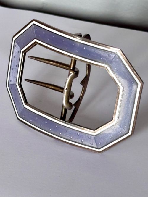 fig 1. An octagonal antique silver belt buckle featuring lavender guilloche enamel bordered in white enamel with a central metal prong mechanism.