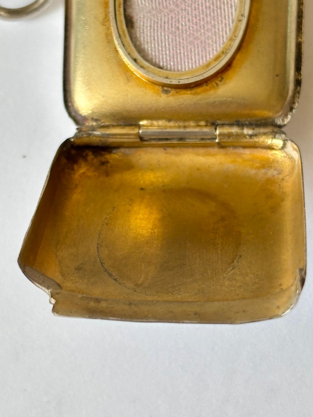 An opened Victorian sterling silver vesta case with an integrated oval photo frame, showing hinged covers and an interior gold wash. View III