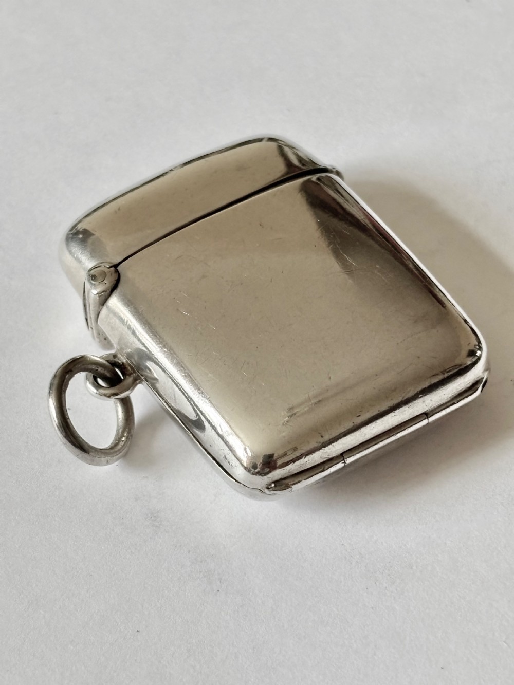 An opened Victorian sterling silver vesta case with an integrated oval photo frame, showing hinged covers and an interior gold wash. View X