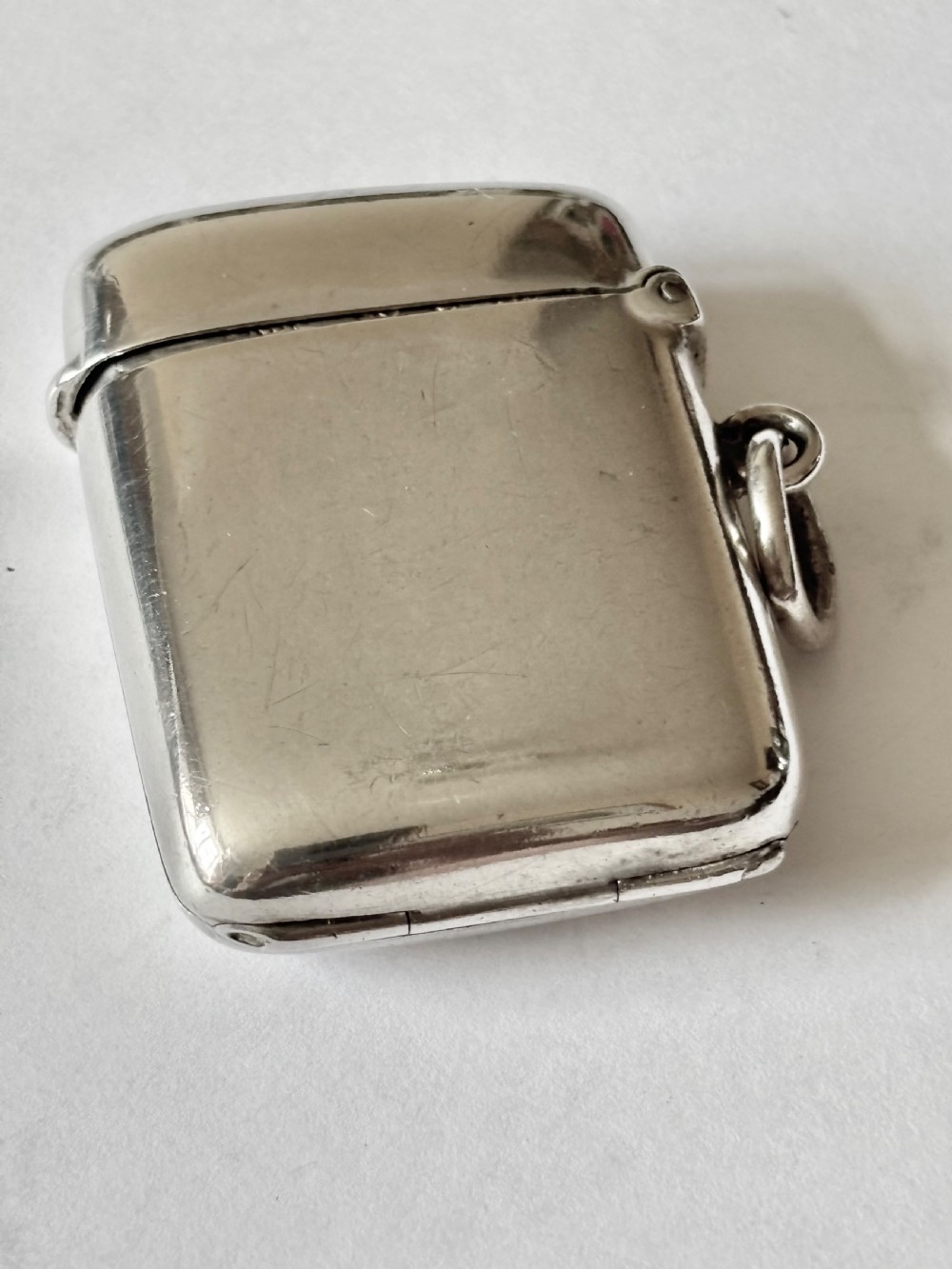 An opened Victorian sterling silver vesta case with an integrated oval photo frame, showing hinged covers and an interior gold wash. View XII