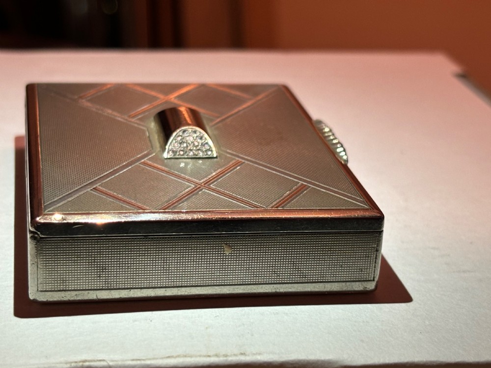 A square Art Deco rose gold vanity box featuring geometric engine-turned patterns and a diamond-paved catch.