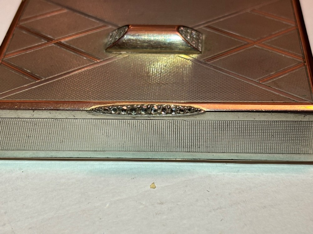 A square Art Deco rose gold vanity box featuring geometric engine-turned patterns and a diamond-paved catch. View VI