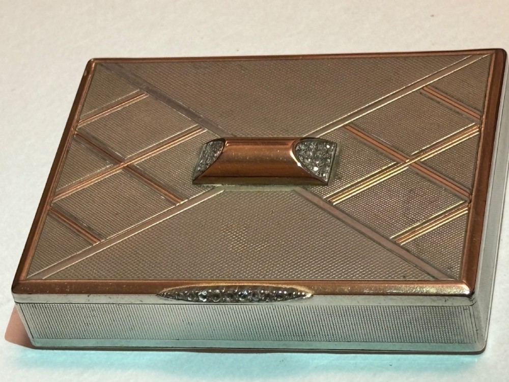 A square Art Deco rose gold vanity box featuring geometric engine-turned patterns and a diamond-paved catch. View XIII