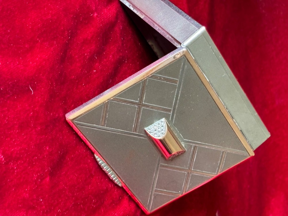 A square Art Deco rose gold vanity box featuring geometric engine-turned patterns and a diamond-paved catch. View XVIII