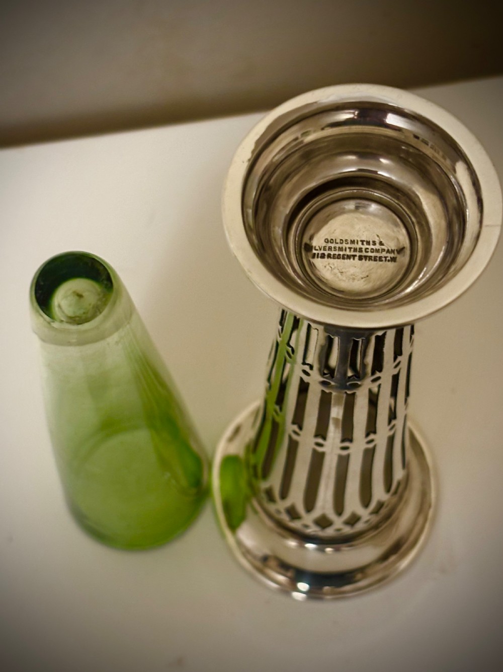 Top-down view of an Edwardian pierced sterling silver vase featuring a flared rim and a dark green glass liner. View III