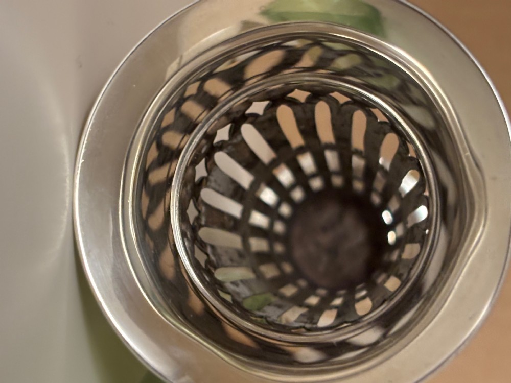 Top-down view of an Edwardian pierced sterling silver vase featuring a flared rim and a dark green glass liner. View VI