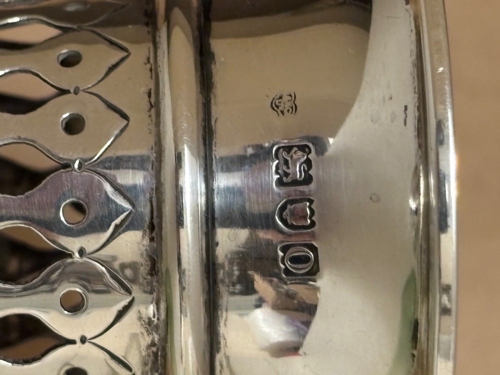 Top-down view of an Edwardian pierced sterling silver vase featuring a flared rim and a dark green glass liner. View XI