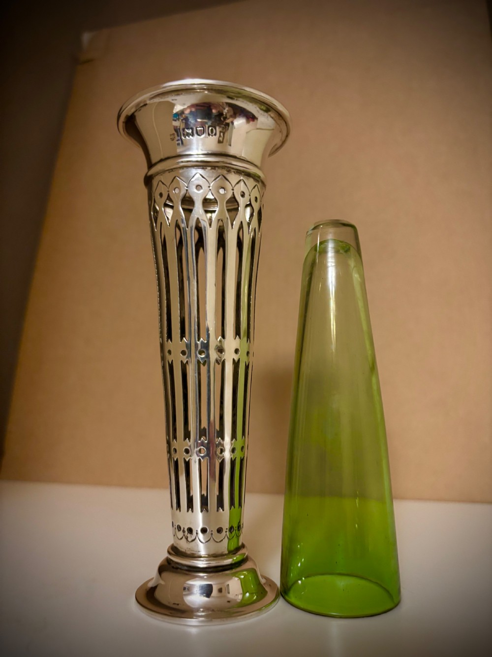 Top-down view of an Edwardian pierced sterling silver vase featuring a flared rim and a dark green glass liner. View XII