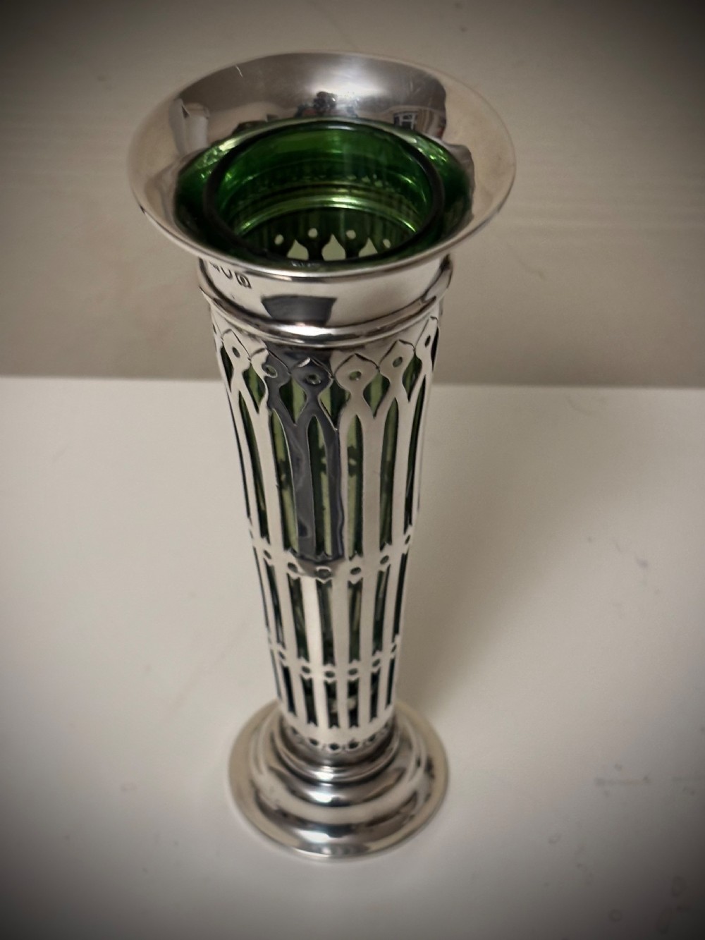 Top-down view of an Edwardian pierced sterling silver vase featuring a flared rim and a dark green glass liner. View XIII