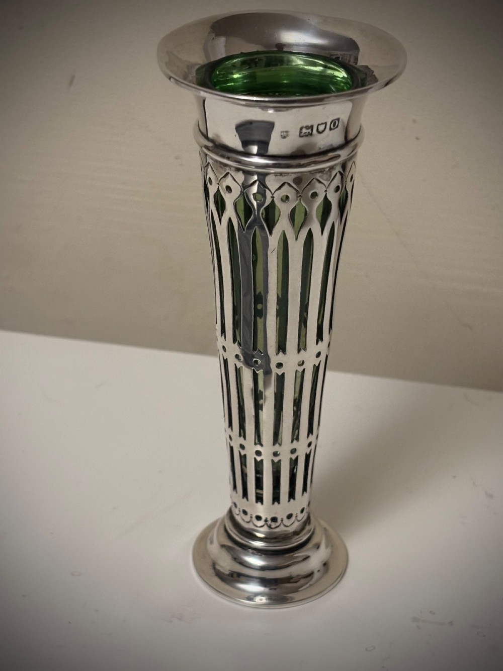 Top-down view of an Edwardian pierced sterling silver vase featuring a flared rim and a dark green glass liner. View XIV