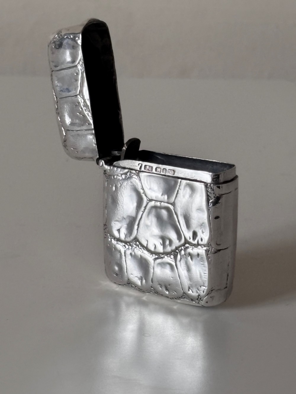 A rectangular Victorian sterling silver pocket vesta case with an embossed crocodile skin texture and hinged lid. View II