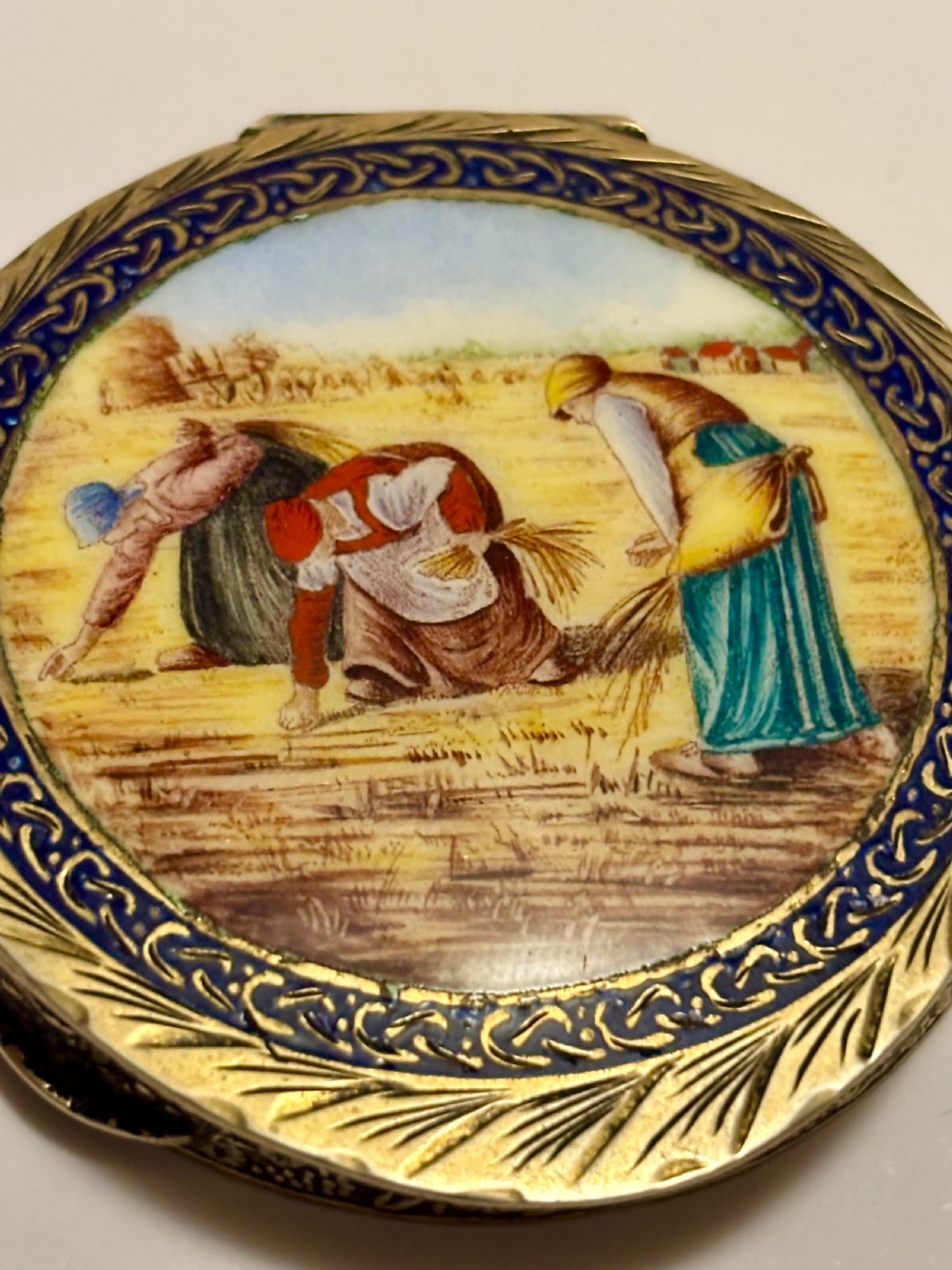 A circular vintage Italian 800 silver powder compact featuring a hand-painted enamel scene of harvest workers framed by a cobalt blue enamel border. View III