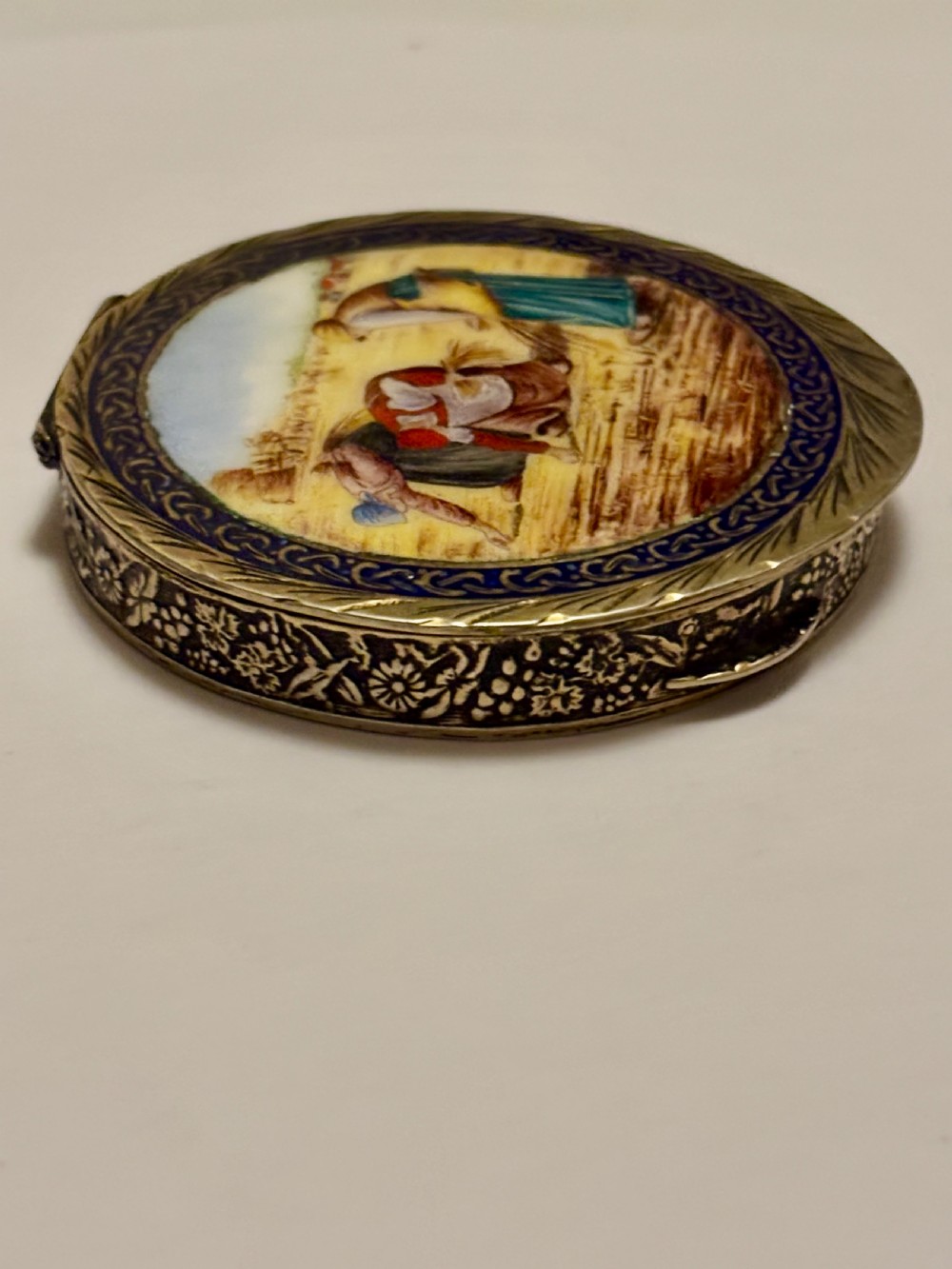 A circular vintage Italian 800 silver powder compact featuring a hand-painted enamel scene of harvest workers framed by a cobalt blue enamel border. View IV