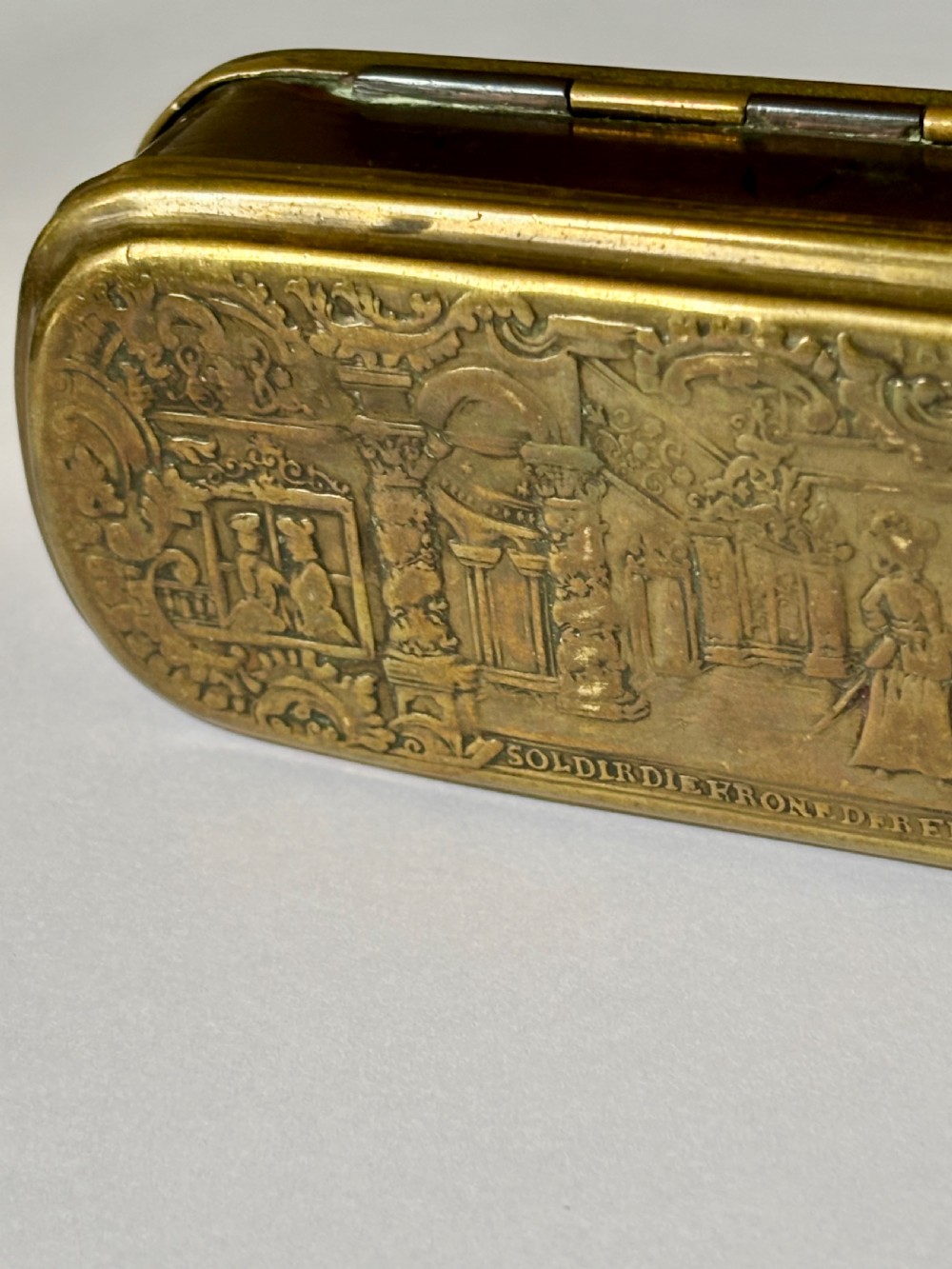 An oblong 18th-century brass and copper tobacco box featuring relief engravings of military battle scenes and portrait medallions on its lid. View XII