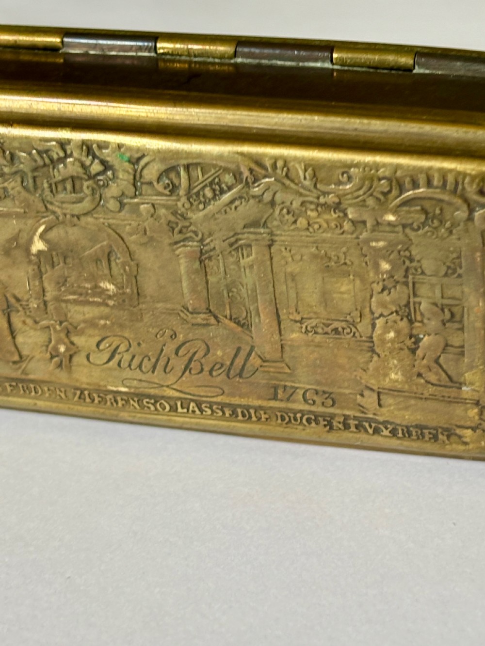 An oblong 18th-century brass and copper tobacco box featuring relief engravings of military battle scenes and portrait medallions on its lid. View XIV