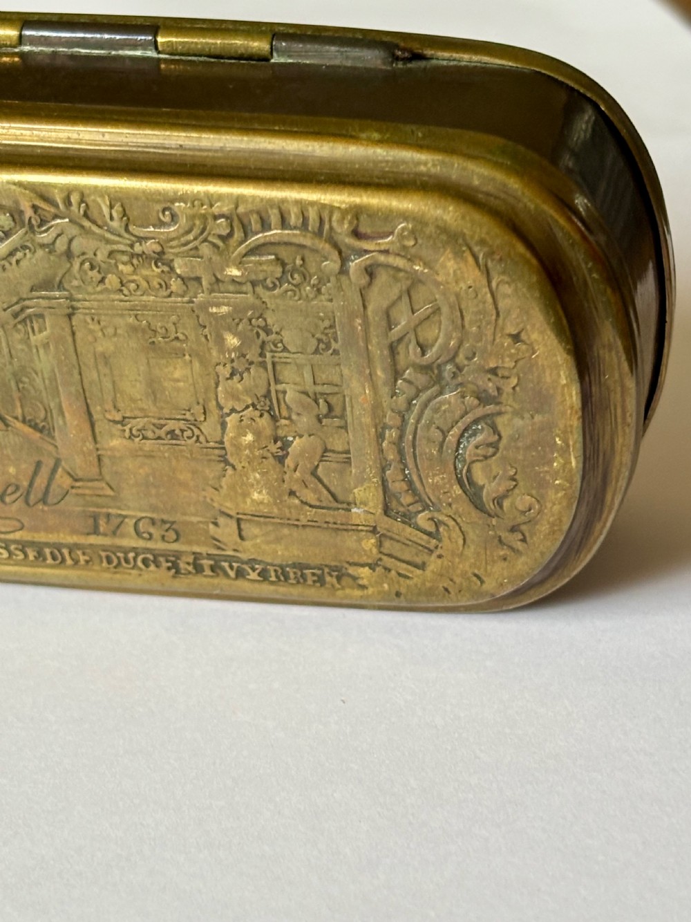 An oblong 18th-century brass and copper tobacco box featuring relief engravings of military battle scenes and portrait medallions on its lid. View XV