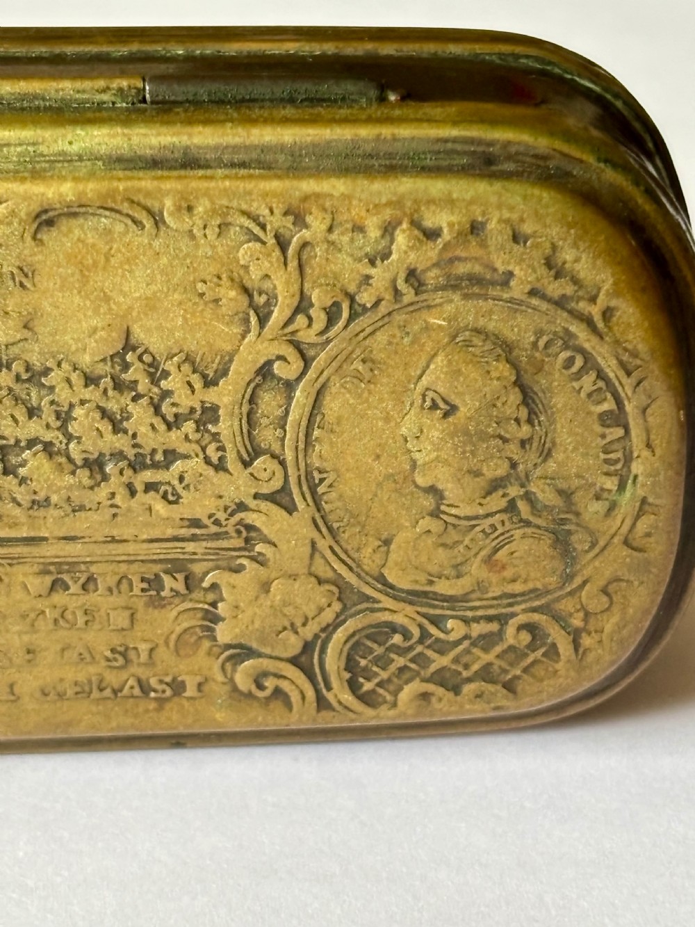 An oblong 18th-century brass and copper tobacco box featuring relief engravings of military battle scenes and portrait medallions on its lid. View XIX