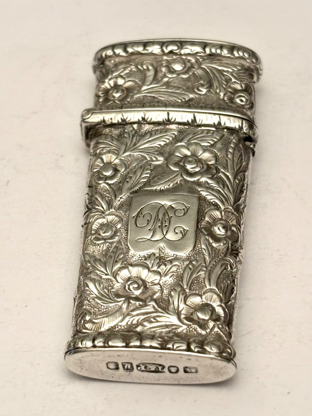 An open William IV sterling silver fleam case with floral chasing, revealing two dark-handled folding blades inside. View IV